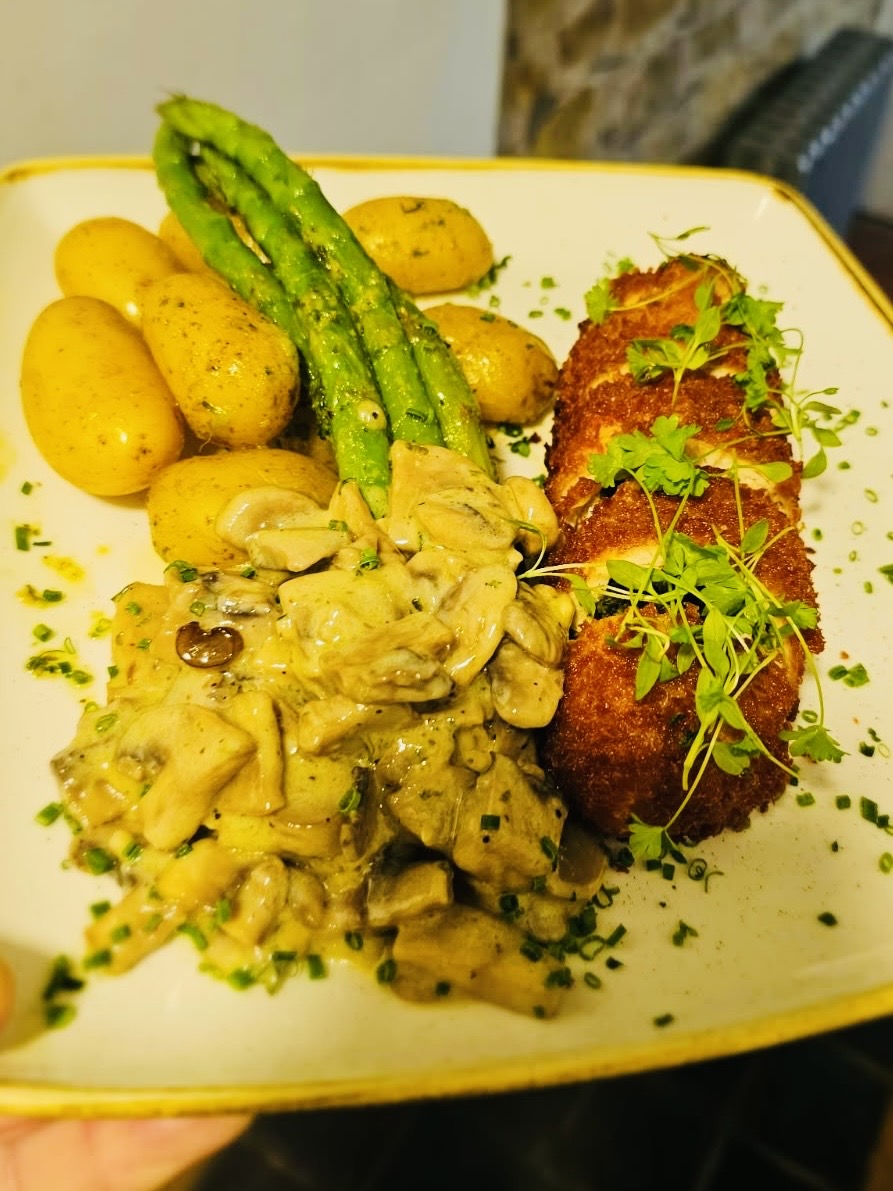 Crispy chicken kiev with mushroom sauce, new potatoes and asparagus at The Ilchester Arms