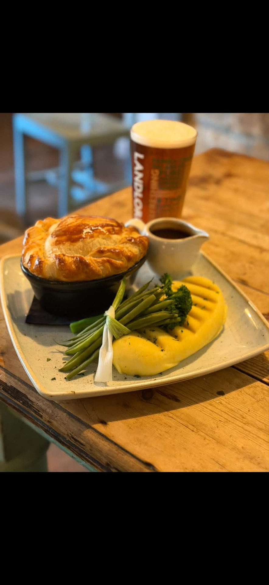Pot pie with mashed potato, green vegetables and gravy served with a pint of ale at The Ilchester Arms